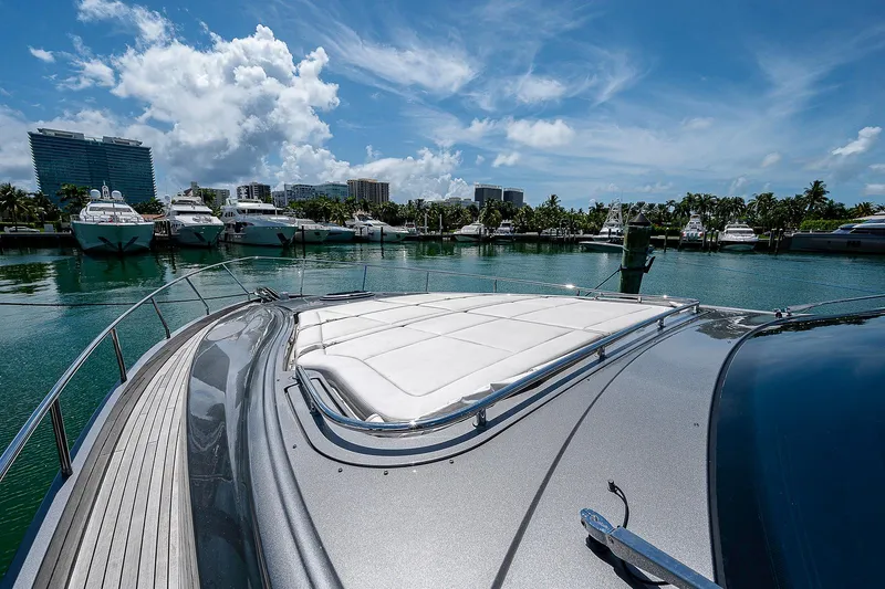 Andiamo Yacht Photos Pics Luxurious 2015 Pershing 70 yacht docked in a scenic marina under a clear blue sky.