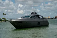 2015 Pershing 70 yacht cruising on a calm, scenic waterway under a cloudy sky.