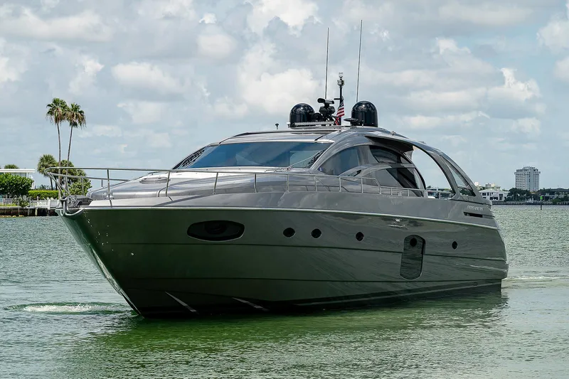 Andiamo Yacht Photos Pics 2015 Pershing 70 yacht cruising on a calm, scenic waterway under a partly cloudy sky.