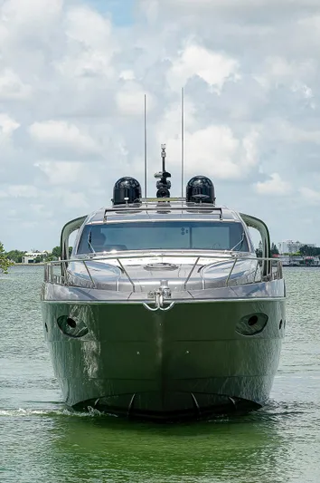 Andiamo Yacht Photos Pics Front view of a 2015 Pershing 70 yacht on calm water under a cloudy sky.