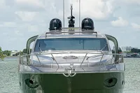 Front view of a 2015 Pershing 70 yacht on calm water under a cloudy sky.