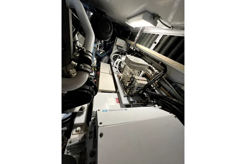  Yacht Photos Pics Engine room of 2003 Hatteras 60 Convertible yacht, showcasing mechanical components and piping.