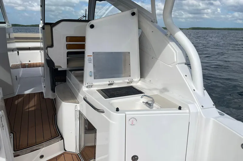 Lady B Yacht Photos Pics 2019 Pursuit DC 365 Dual Console boat interior with kitchenette and seating area.