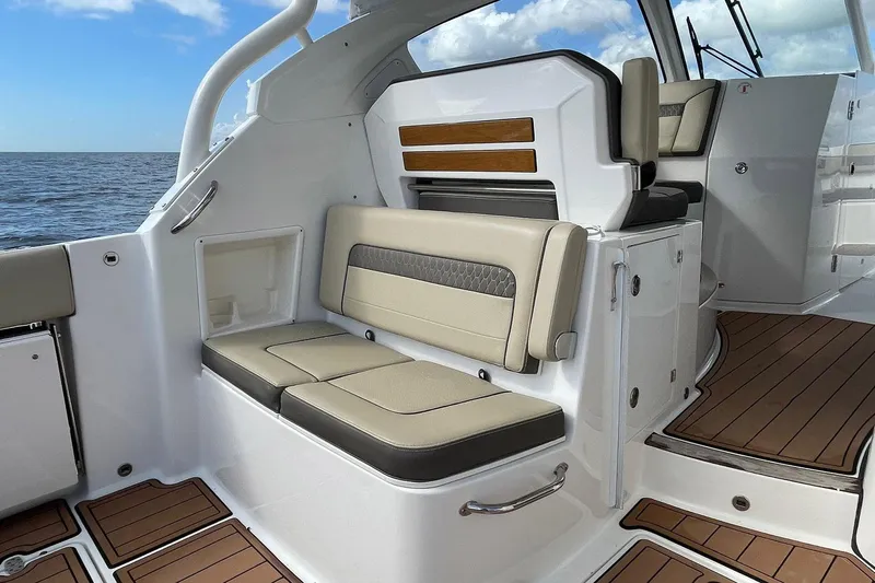 Lady B Yacht Photos Pics 2019 Pursuit DC 365 Dual Console boat interior with beige seating and wood accents.
