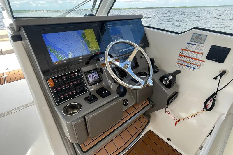Lady B Yacht Photos Pics 2019 Pursuit DC 365 Dual Console helm with navigation screens and steering wheel on open water.