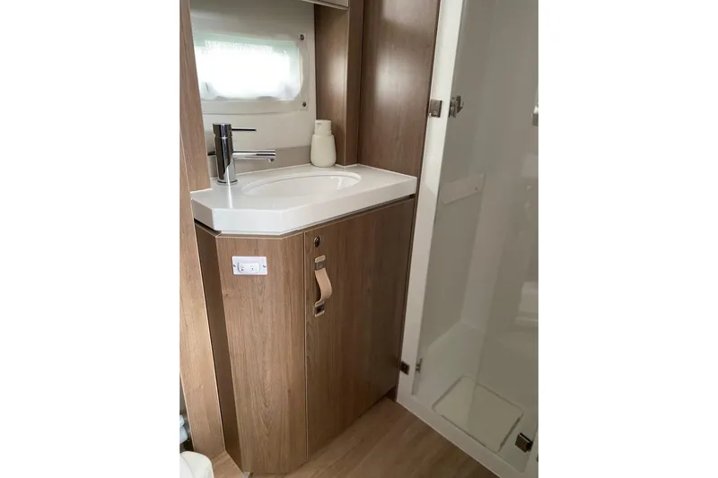 Nia Yacht Photos Pics Modern bathroom in 2022 Bali 4.6 model, featuring sleek sink and wooden cabinetry.