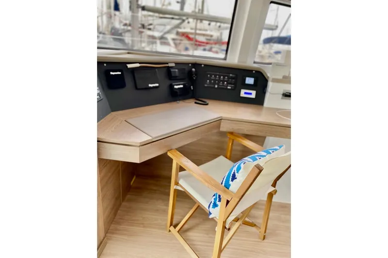 Nia Yacht Photos Pics Modern yacht interior with wooden desk and chair, featuring control panels. Bali 4.6, 2022 model.