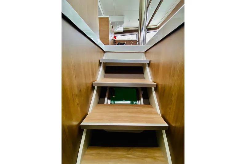Nia Yacht Photos Pics Wooden interior stairs on a 2022 Bali 4.6 yacht, leading to upper deck.