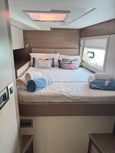 Nia Yacht Photos Pics Cozy bedroom in 2022 Bali 4.6 yacht with nautical-themed pillows and rolled towels.