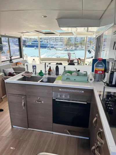 Nia Yacht Photos Pics Modern yacht kitchen interior with appliances, overlooking marina through large windows. Bali 4.6, 2022 model.