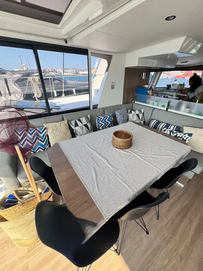 Nia Yacht Photos Pics Modern Bali 4.6 yacht interior with dining area, cushions, and sea view, 2022 model.