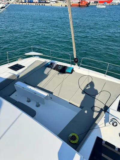 Nia Yacht Photos Pics Bali 4.6 yacht deck with seating, overlooking calm waters and distant harbor, 2022 model.