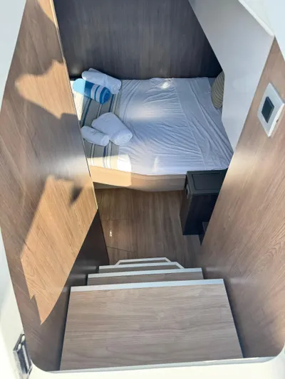 Nia Yacht Photos Pics Cozy cabin interior of 2022 Bali 4.6 yacht with bed and wooden stairs.