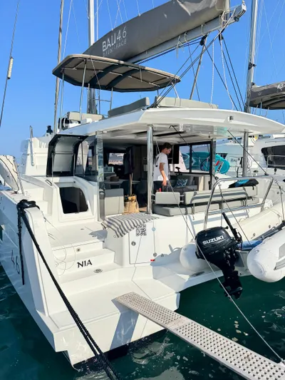 Nia Yacht Photos Pics 2022 Bali 4.6 catamaran docked, featuring spacious deck and Suzuki outboard motor.