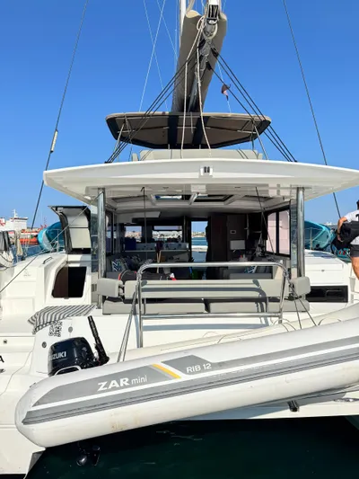 Nia Yacht Photos Pics Modern Bali 4.6 catamaran with ZAR mini RIB 12, docked in a sunny marina, 2022 model.