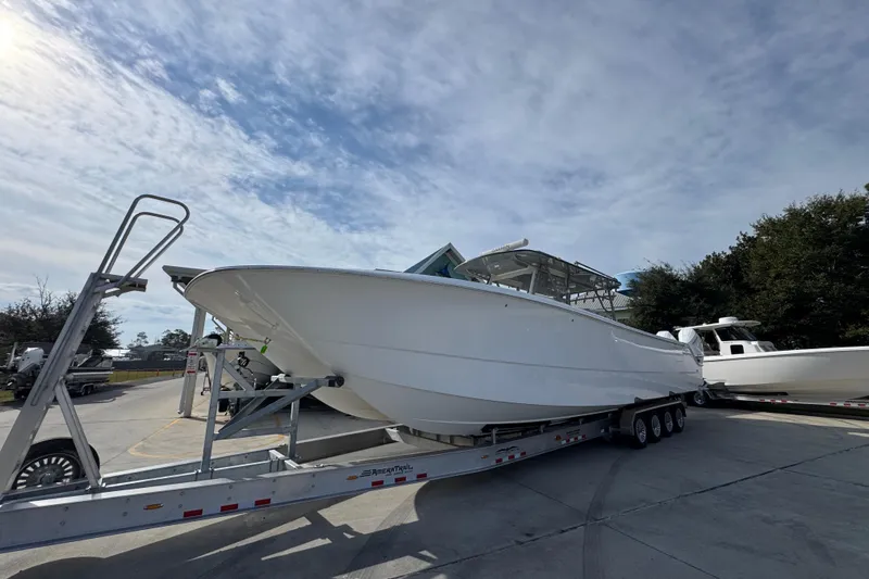  Yacht Photos Pics 2023 Invincible 46 Catamaran on trailer under a partly cloudy sky.