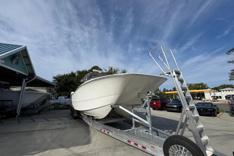  Yacht Photos Pics 2023 Invincible 46 Catamaran on trailer under clear sky, parked near buildings.