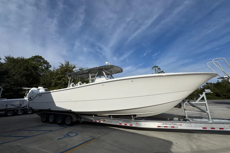  Yacht Photos Pics 2023 Invincible 46 Catamaran on trailer under blue sky, side view.