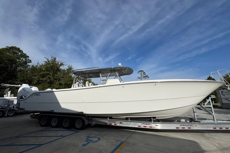  Yacht Photos Pics 2023 Invincible 46 Catamaran on trailer, parked outdoors under blue sky.