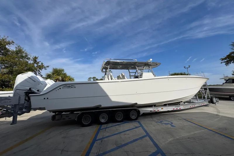  Yacht Photos Pics 2023 Invincible 46 Catamaran on trailer, parked outdoors under blue sky.