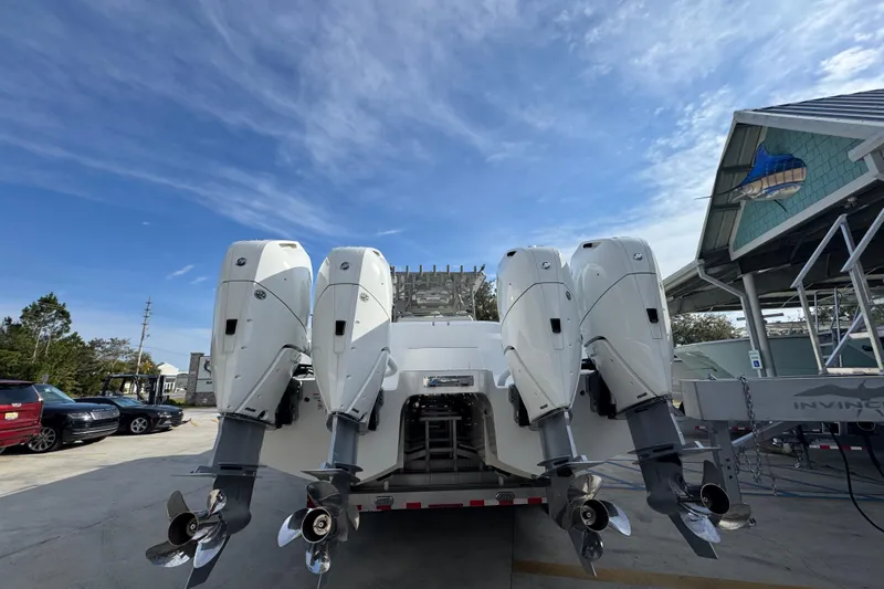  Yacht Photos Pics 2023 Invincible 46 Catamaran with four powerful outboard engines, docked under a clear sky.