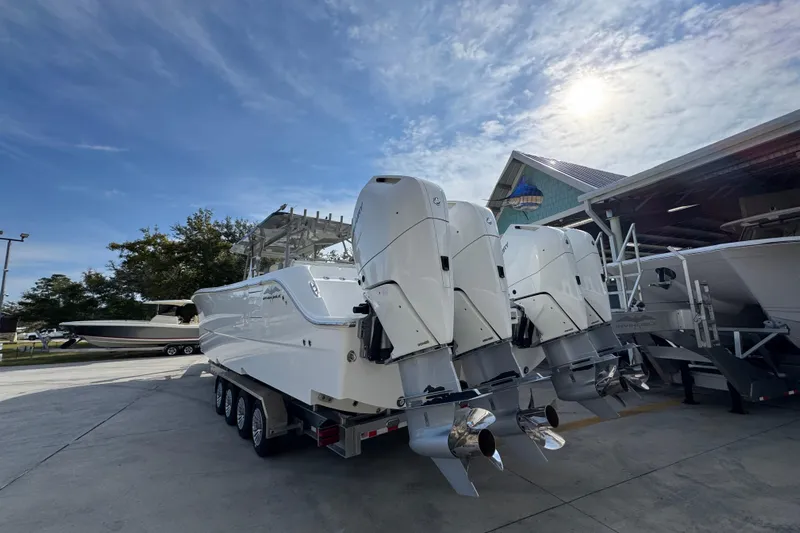  Yacht Photos Pics 2023 Invincible 46 Catamaran with powerful outboard engines, parked outdoors under a sunny sky.