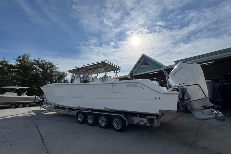  Yacht Photos Pics 2023 Invincible 46 Catamaran on trailer under sunny sky at marina.