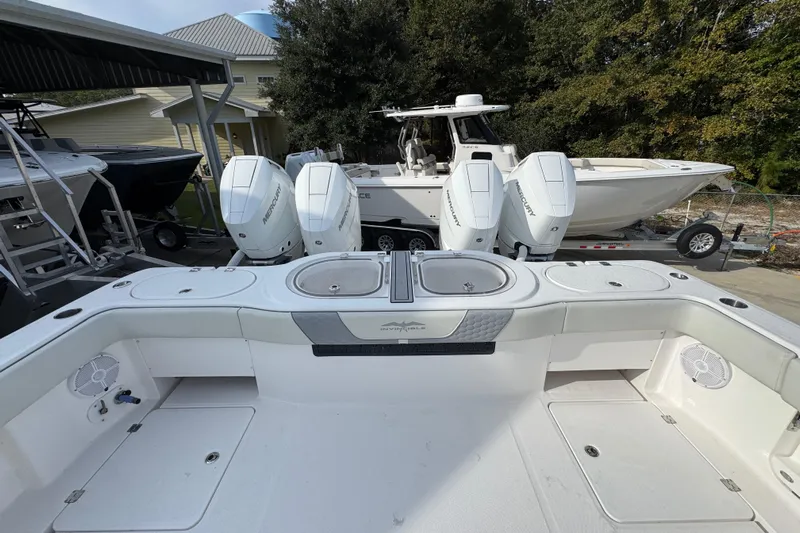  Yacht Photos Pics 2023 Invincible 46 Catamaran with powerful Mercury outboard engines, docked outdoors.