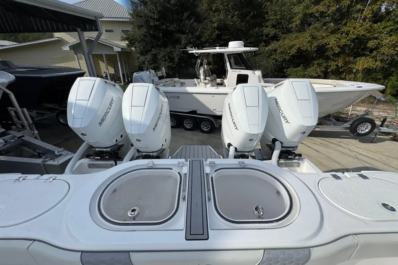  Yacht Photos Pics 2023 Invincible 46 Catamaran with four Mercury outboard engines, docked near other boats.