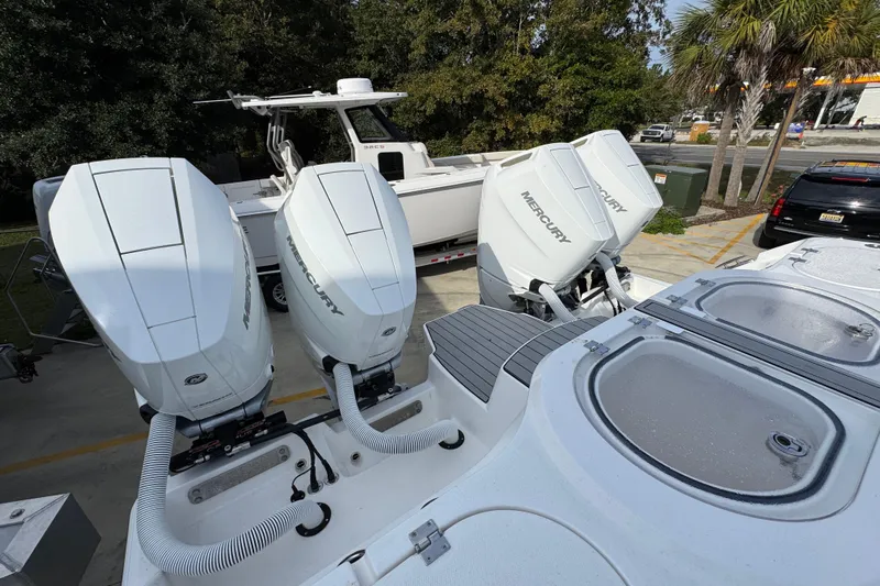  Yacht Photos Pics 2023 Invincible 46 Catamaran with triple Mercury outboard engines, parked outdoors.