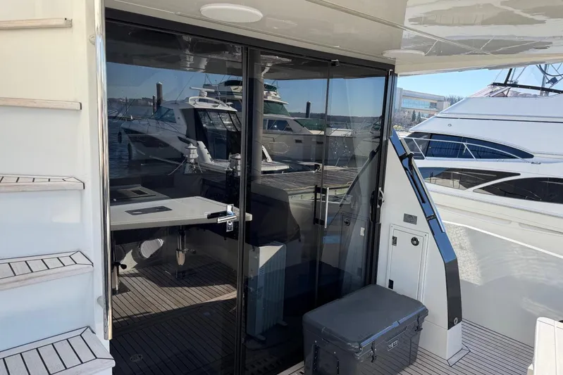 Dream Yacht Photos Pics 2019 Galeon 470 Sky yacht with glass doors and docked boats in the background.