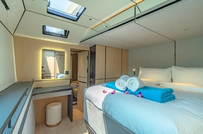 Jack Yacht Photos Pics Luxurious McConaghy MC75 2023 yacht bedroom with skylights, modern decor, and neatly arranged towels.