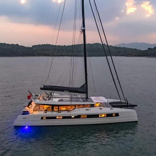 Jack Yacht Photos Pics 2023 McConaghy MC75 yacht on serene water at sunset, illuminated with blue lights.