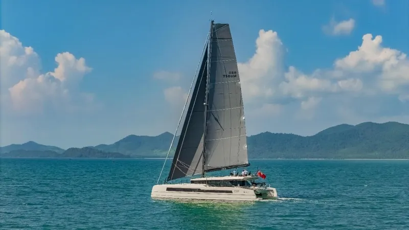 Jack Yacht Photos Pics 2023 McConaghy MC75 sailing on blue ocean with scenic mountain backdrop.