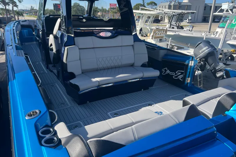  Yacht Photos Pics 2026 Nor-Tech 450 Sport boat interior with blue and gray seating, docked outdoors.