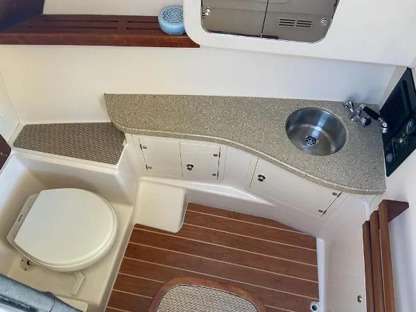  Yacht Photos Pics 2013 Grady-White Freedom 335 boat interior with sink, toilet, and wooden flooring.