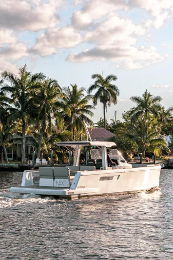 Next Yacht Photos Pics 2022 Fjord 38 Open cruising on a tropical waterway with palm trees.