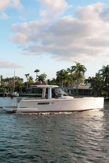 Next Yacht Photos Pics 2022 Fjord 38 Open yacht cruising on a scenic waterway with palm trees.