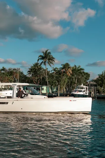 Next Yacht Photos Pics 2022 Fjord 38 Open yacht cruising on a sunny day with palm trees in the background.