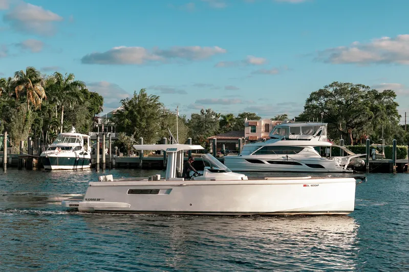 Next Yacht Photos Pics 2022 Fjord 38 Open yacht cruising on a scenic waterfront with other boats.