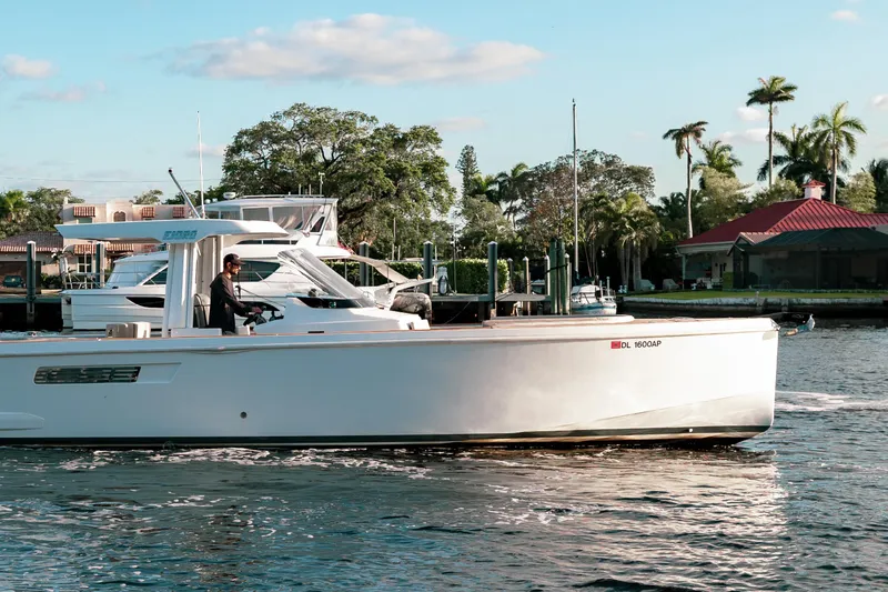 Next Yacht Photos Pics 2022 Fjord 38 Open boat cruising on a sunny day near a marina.