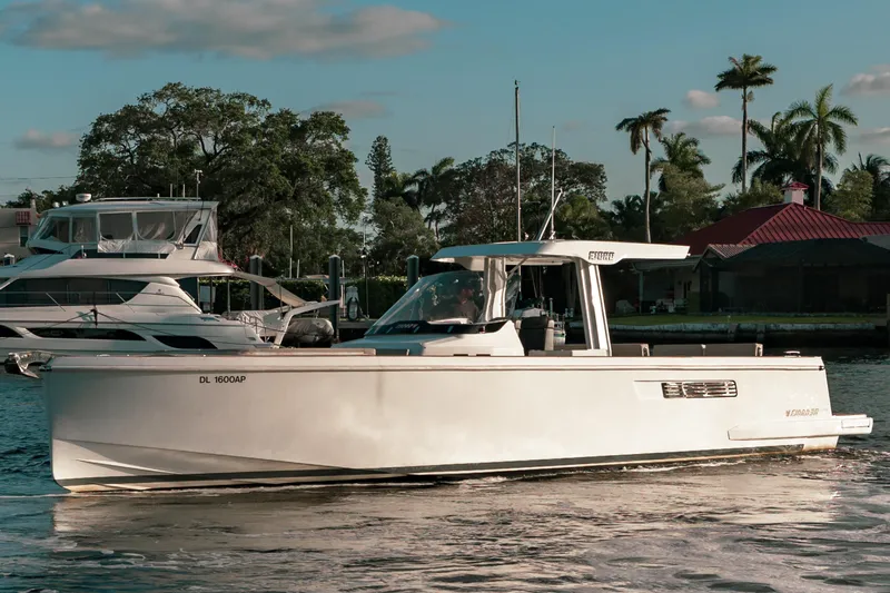 Next Yacht Photos Pics 2022 Fjord 38 Open boat cruising on a sunny day, surrounded by palm trees.