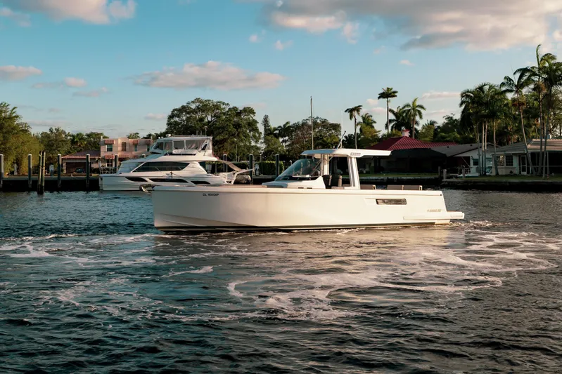 Next Yacht Photos Pics 2022 Fjord 38 Open boat cruising on a sunny day near a marina.