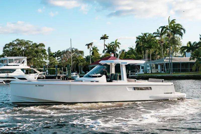 Next Yacht Photos Pics 2022 Fjord 38 Open cruising on a scenic waterway with palm trees in the background.