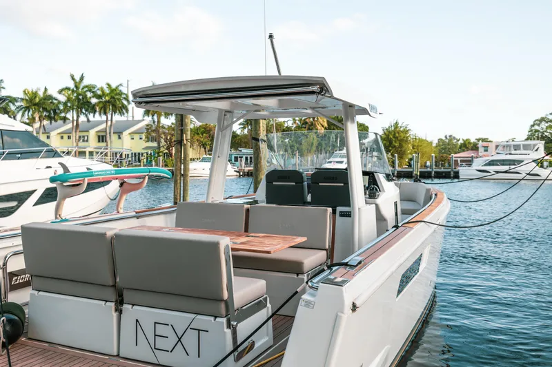 Next Yacht Photos Pics 2022 Fjord 38 Open boat docked, featuring sleek design and spacious seating area.