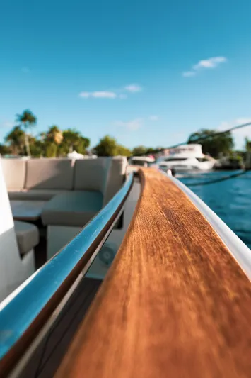 Next Yacht Photos Pics 2022 Fjord 38 Open yacht with sleek wooden railing and scenic water view.