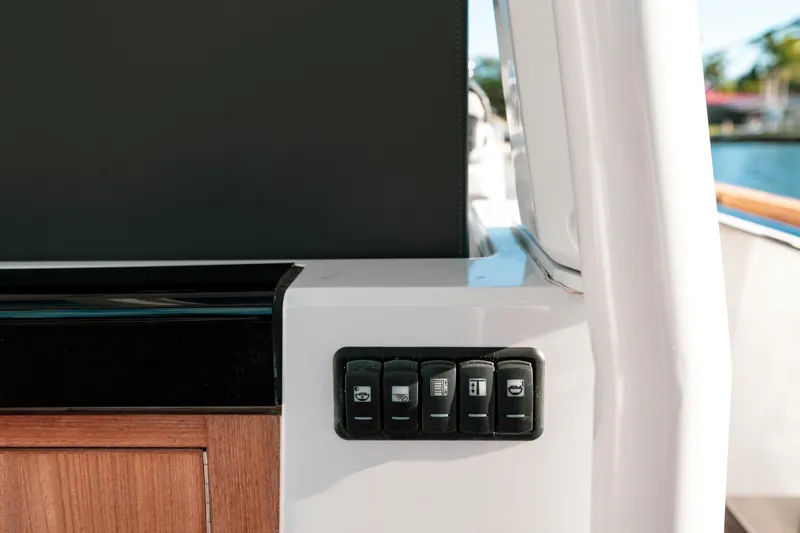Next Yacht Photos Pics Control panel on 2022 Fjord 38 Open yacht, featuring sleek design and wooden accents.