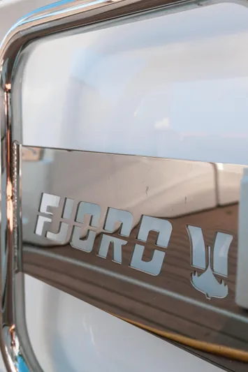 Next Yacht Photos Pics Close-up of 2022 Fjord 38 Open boat logo on metallic surface.