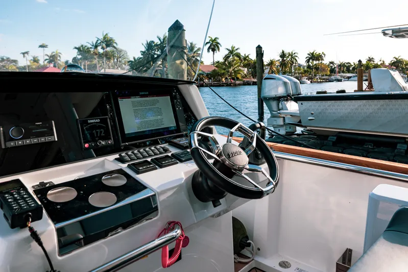 Next Yacht Photos Pics Interior view of 2022 Fjord 38 Open yacht cockpit with steering wheel and navigation system.