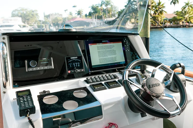 Next Yacht Photos Pics 2022 Fjord 38 Open boat dashboard with steering wheel and navigation screens.